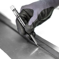 Hand wearing a glove marking a line on metal with the Pica Dry Marking Pencil